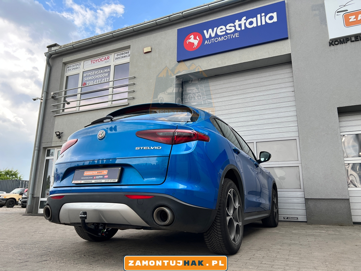 Alfa romeo Stelvio Q4 - zdjecie z prawej strony z narożnika, na zdjeciu samochod po montazu haka holowniczego na tle profesjonalnego warsztatu montujacego haki holownicze w poznaniu